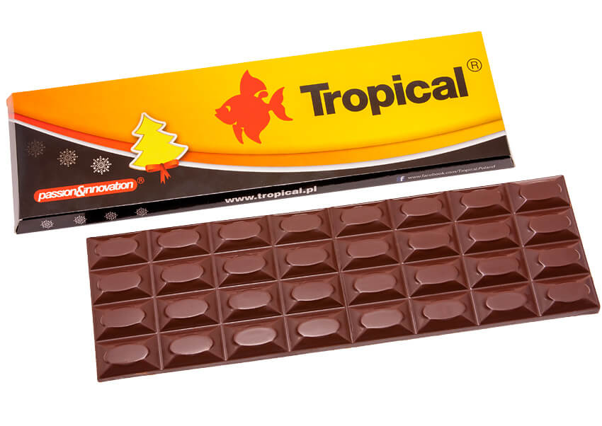 Duża mleczna czekolada 44%, zapakowana w przezroczystą foliową torebkę na złotej wyprasce z firmowym nadrukiem