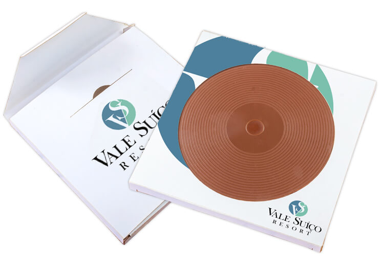 Okrągła czekolada w kształcie winylowej płyty gramofonowej w mlecznej wersji z firmowym nadrukiem reklamowym na opakowaniu